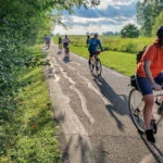 A group of bike riders on the Salomon Farm Park Loop. One rider is waving to the camera.